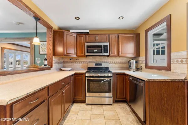 a kitchen with stainless steel appliances granite countertop a refrigerator a sink and dishwasher