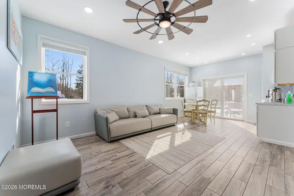a kitchen with stainless steel appliances granite countertop a table chairs and a refrigerator a sink with white cabinets