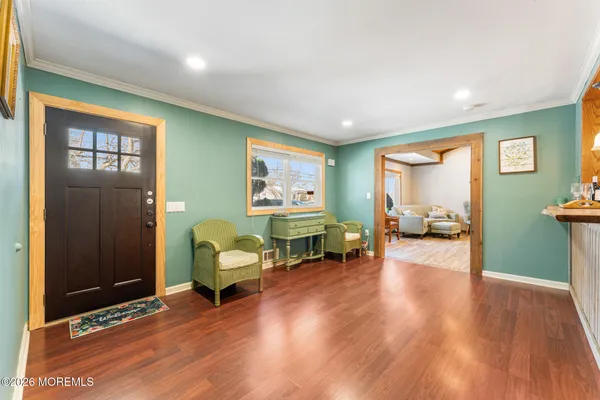 a living room with furniture wooden floor and a kitchen