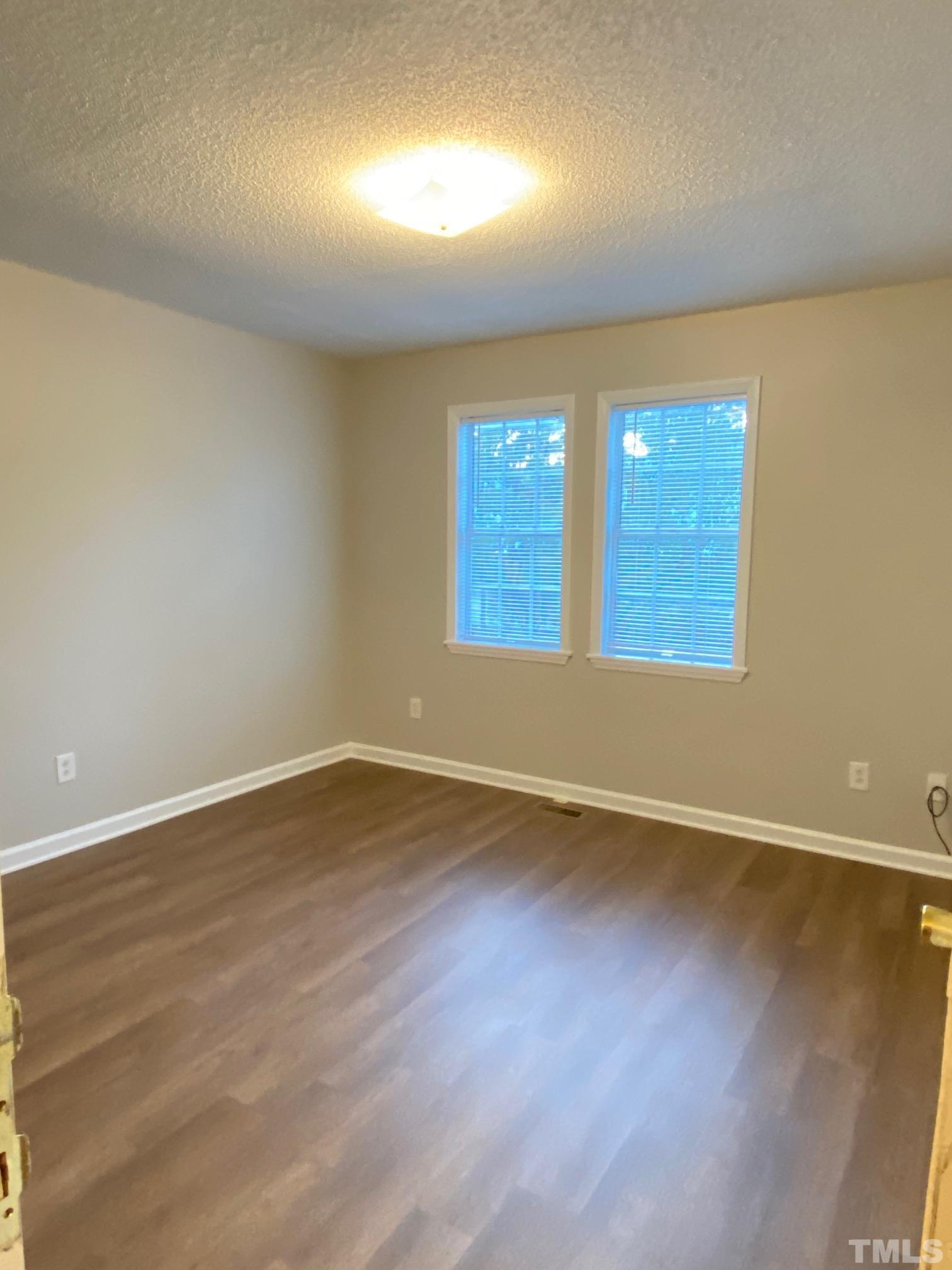 4232 Kaplan Drive Raleigh, NC 27606 - Photo 14 of 21 an empty room with wooden floor and windows