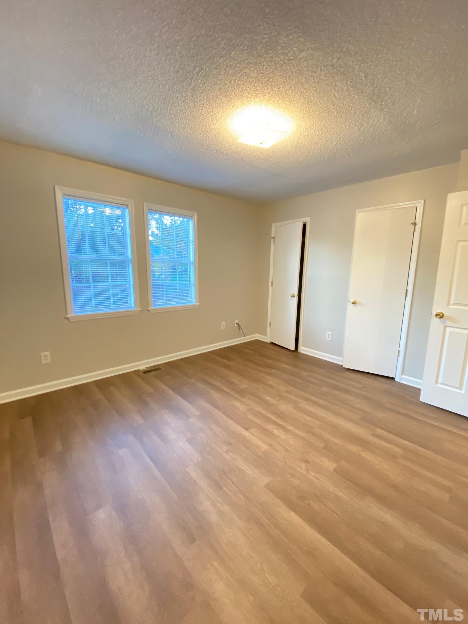 4232 Kaplan Drive Raleigh, NC 27606 - Photo 15 of 21 an empty room with wooden floor and windows