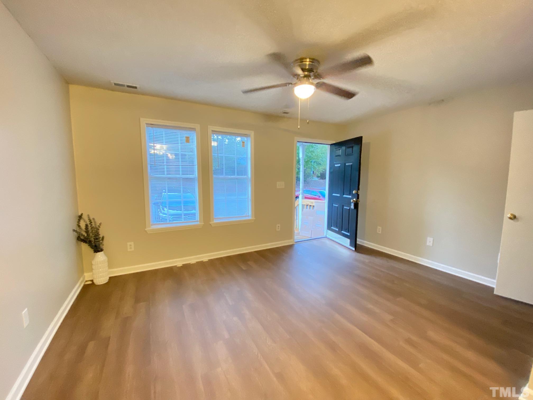 4232 Kaplan Drive Raleigh, NC 27606 - Photo 7 of 21 a view of an empty room with wooden floor and a ceiling fan
