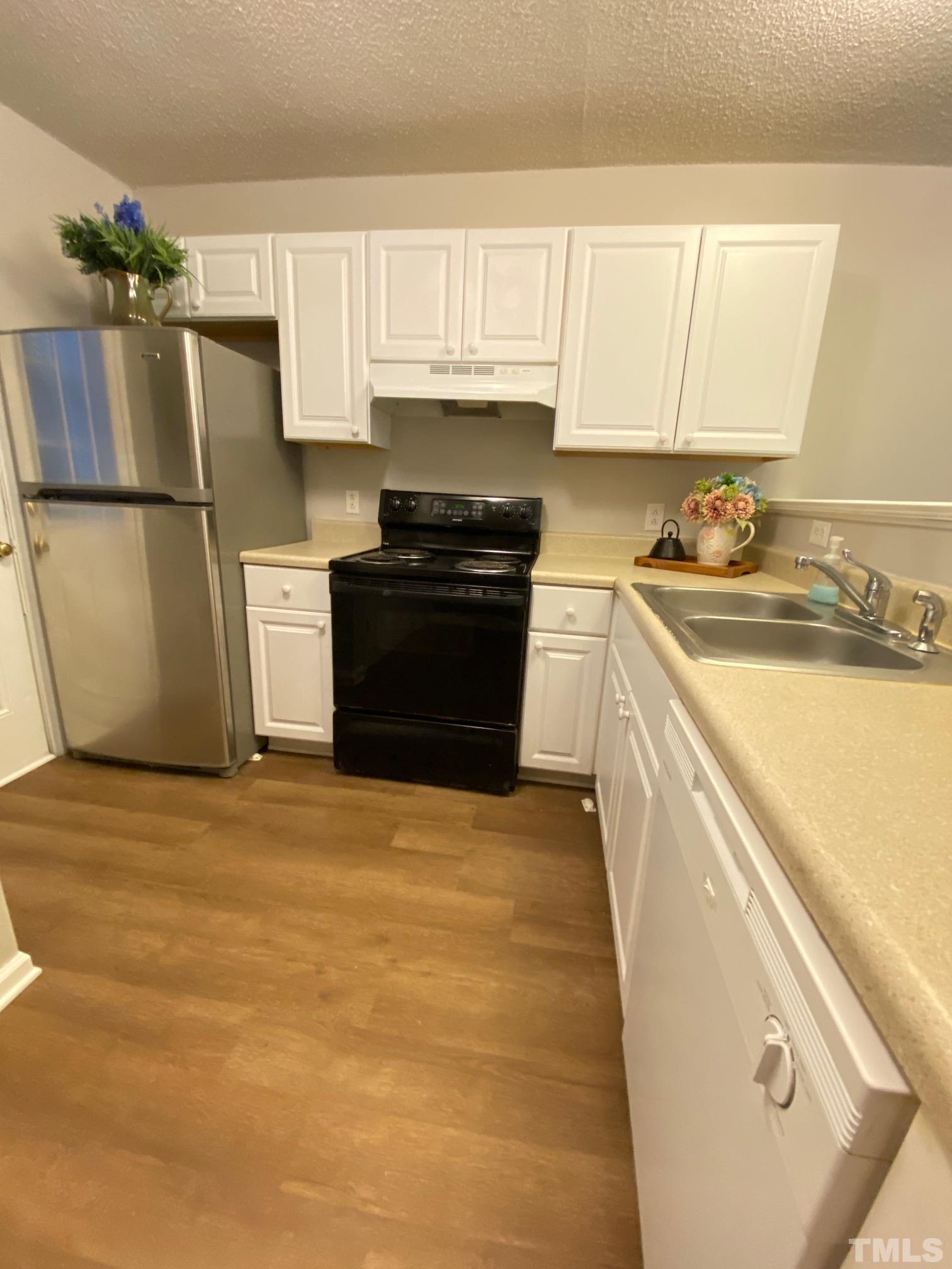 4232 Kaplan Drive Raleigh, NC 27606 - Photo 8 of 21 a kitchen with a refrigerator sink and cabinets