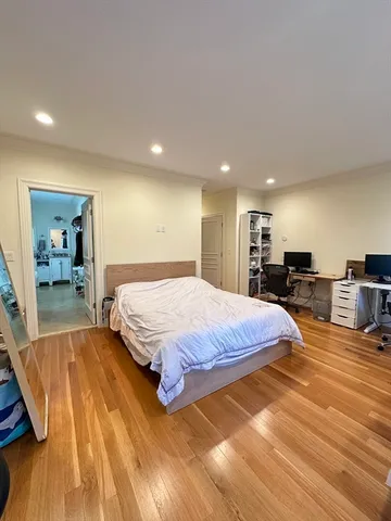 a spacious bedroom with a bed and a view of living room