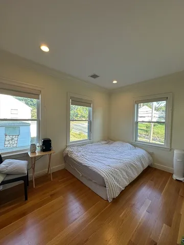 a bedroom with a bed and wooden floor
