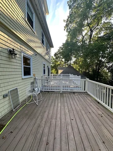 a backyard of a house with wooden floor and fence