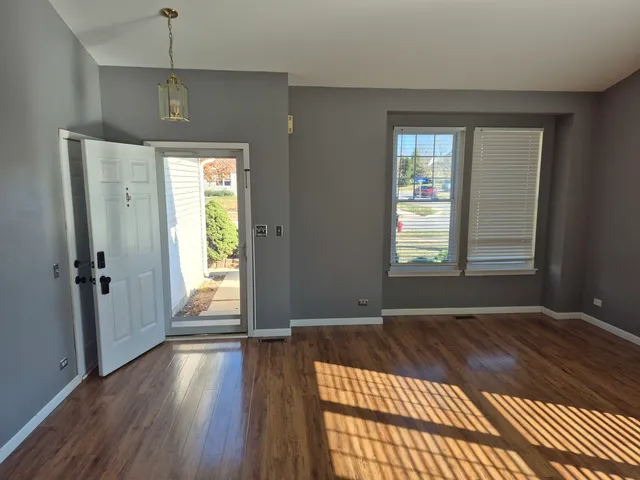 a view of a room with wooden floor and a window