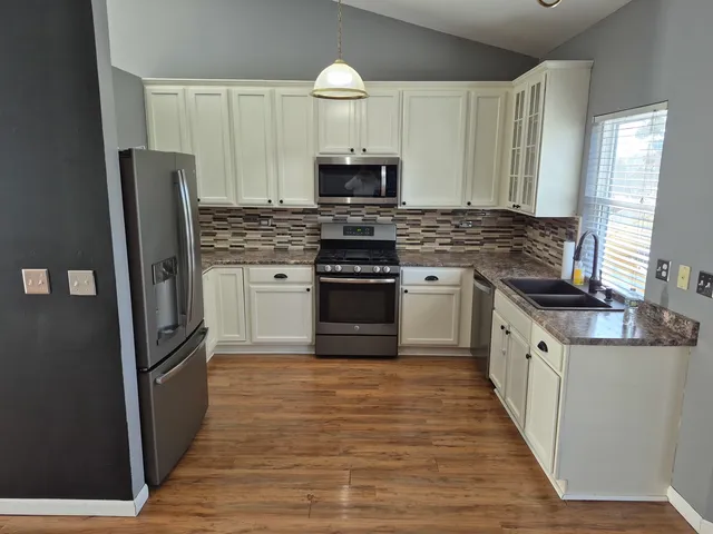 a kitchen with stainless steel appliances granite countertop a stove and a refrigerator