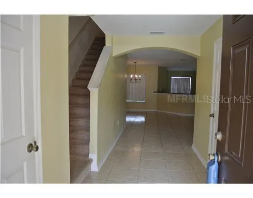 a view of a hallway with wooden floor and a bathroom