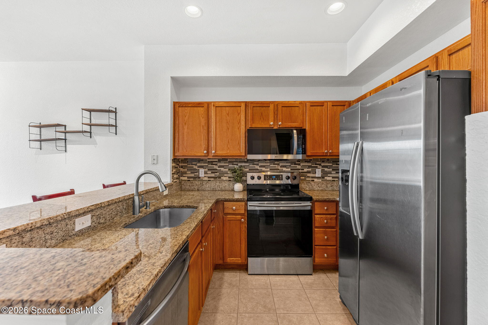 110 Turpial Way, Unit 106 Melbourne, FL 32901 - Photo 15 of 50 a kitchen with stainless steel appliances granite countertop a sink stove and refrigerator