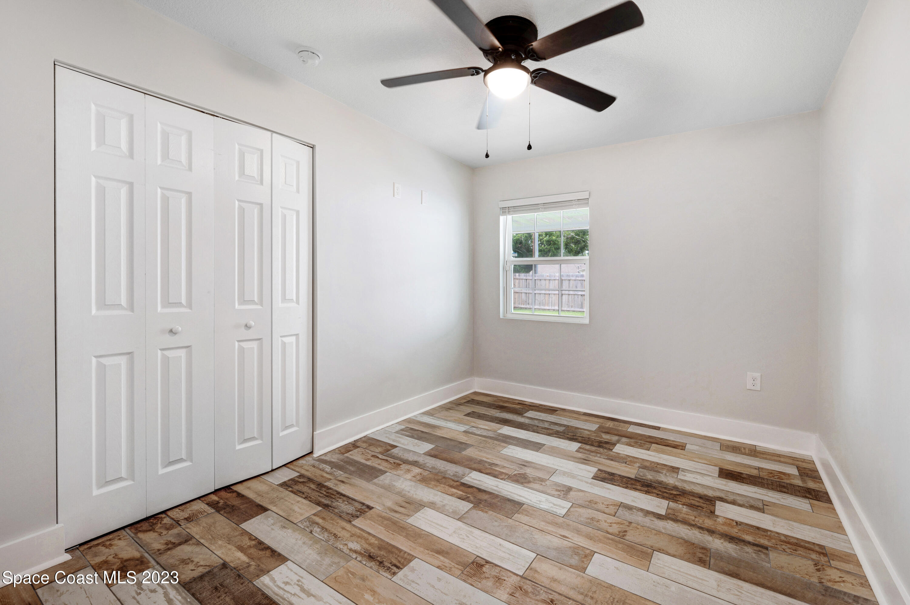 1720 Elizabeth Street Melbourne, FL 32901 - Photo 18 of 33 an empty room with windows and ceiling fan