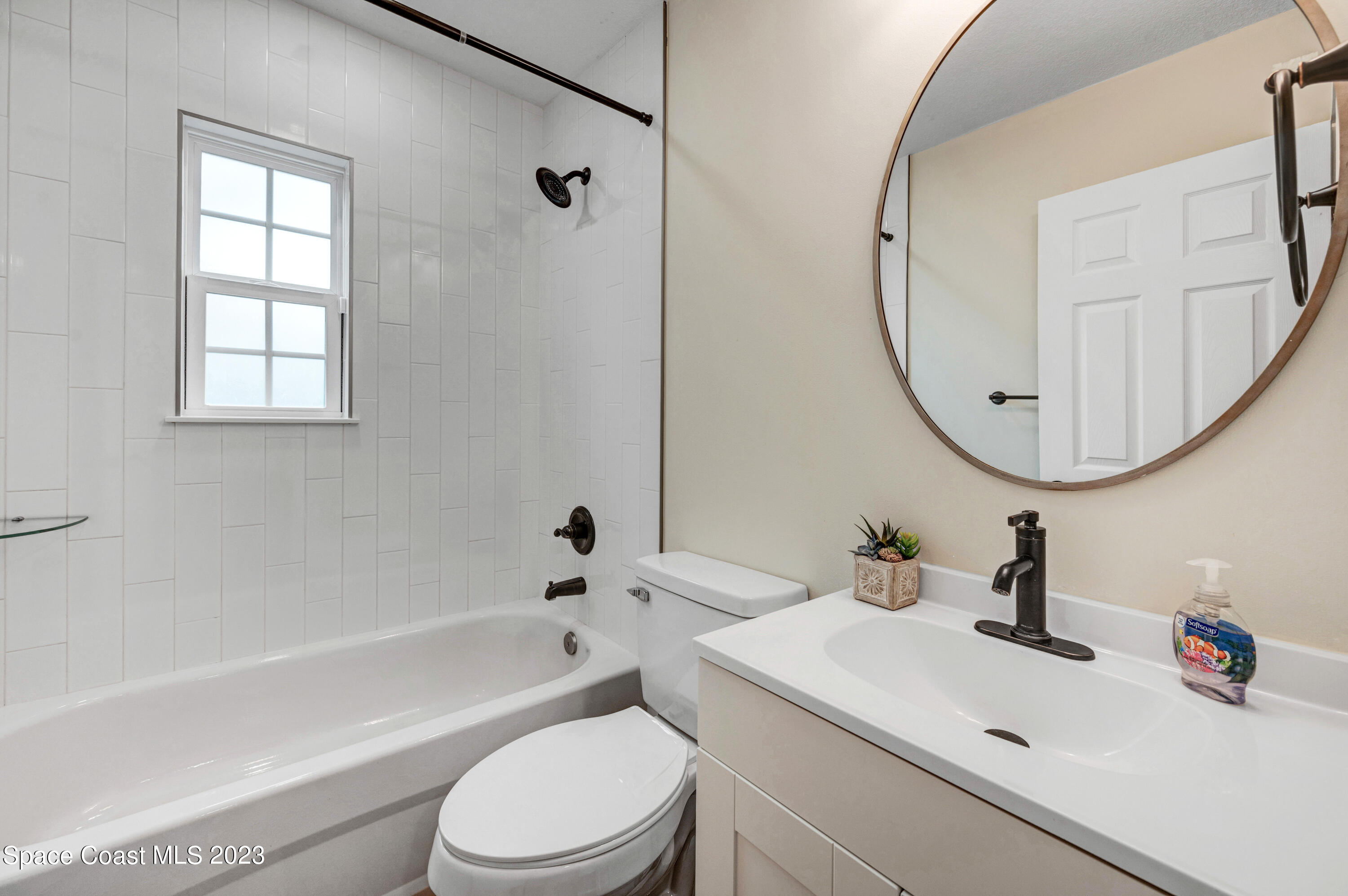 1720 Elizabeth Street Melbourne, FL 32901 - Photo 20 of 33 a bathroom with a sink a toilet and a mirror