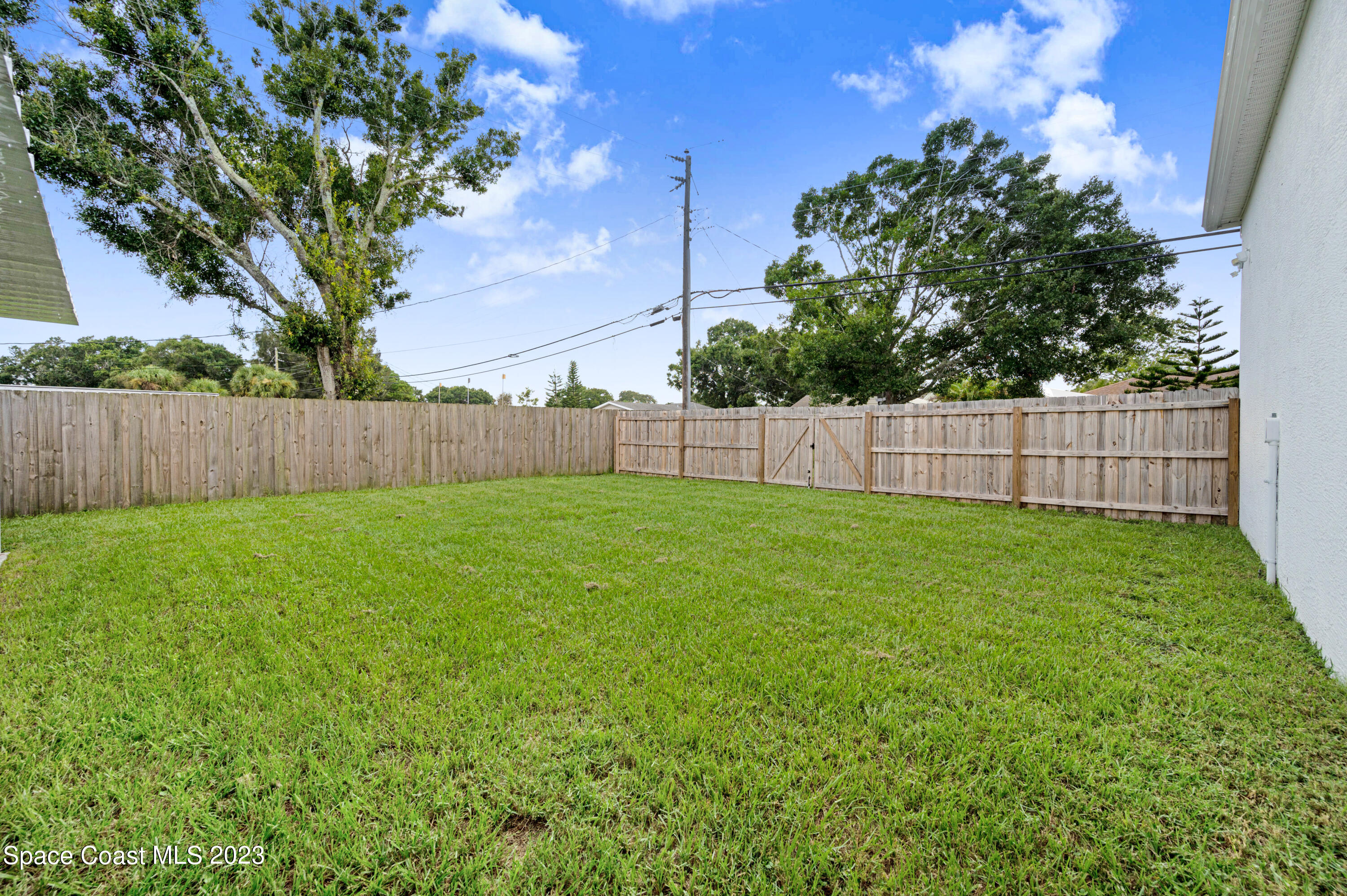 1720 Elizabeth Street Melbourne, FL 32901 - Photo 26 of 33 a view of a backyard with a large tree and wooden fence