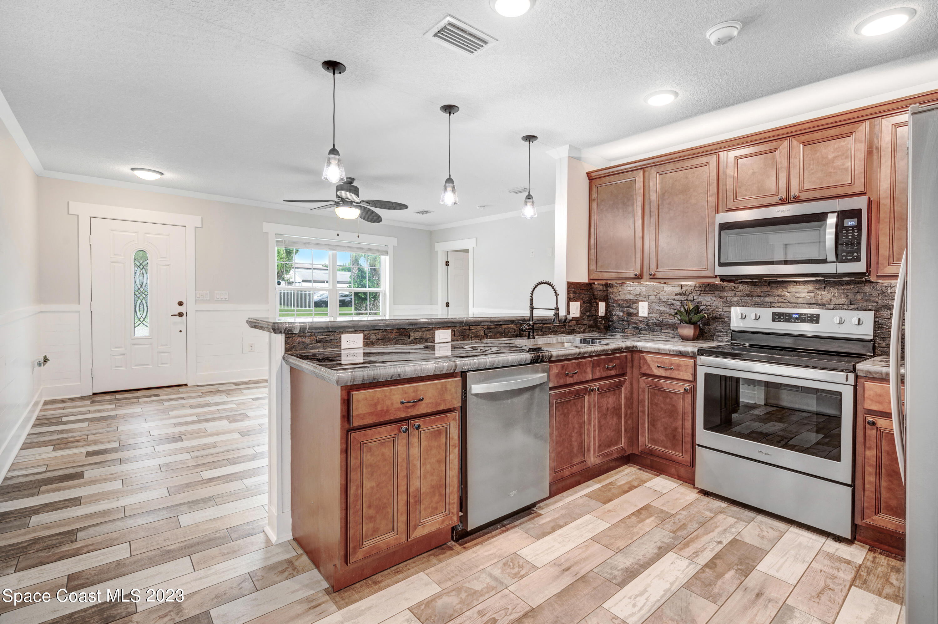 1720 Elizabeth Street Melbourne, FL 32901 - Photo 4 of 33 a kitchen with stainless steel appliances granite countertop a stove a sink and a microwave