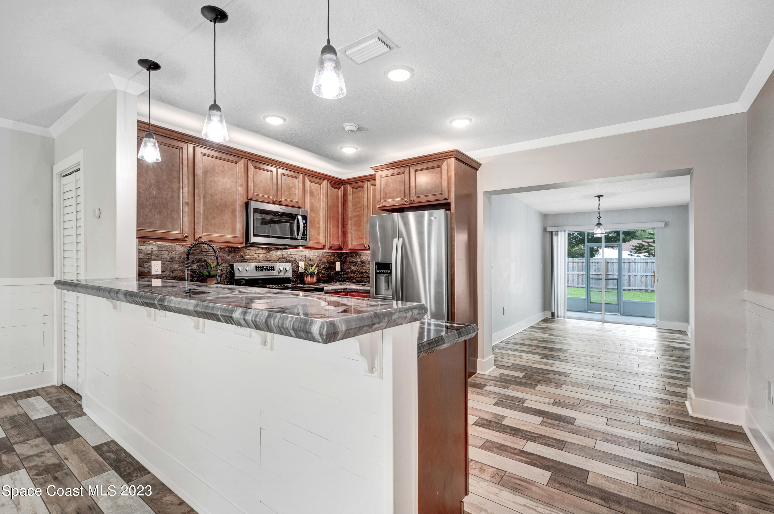 1720 Elizabeth Street Melbourne, FL 32901 - Photo 6 of 33 a view of a kitchen with granite countertop a refrigerator and microwave