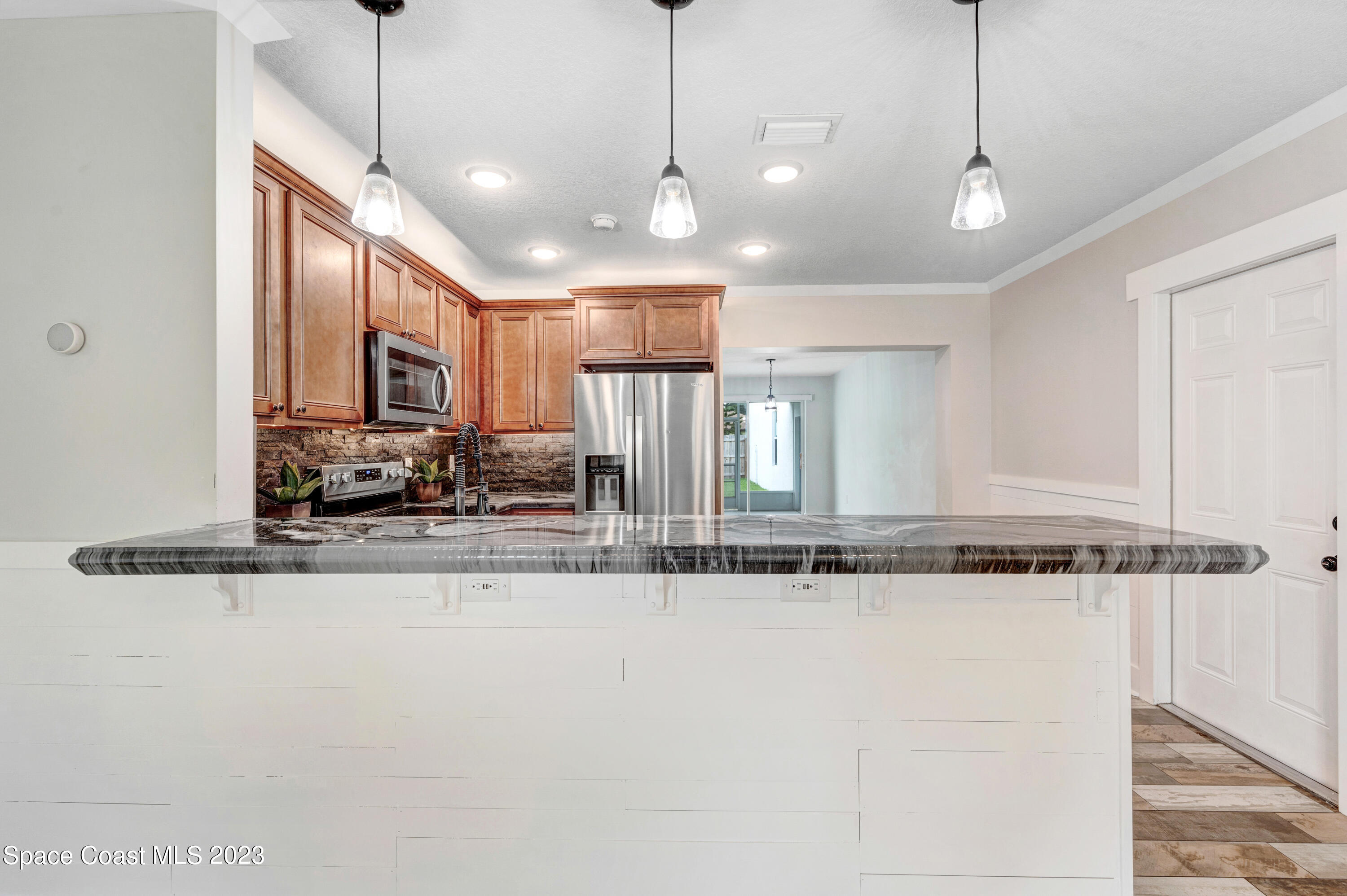 1720 Elizabeth Street Melbourne, FL 32901 - Photo 7 of 33 a view of a kitchen with stainless steel appliances granite countertop a sink and a counter top space