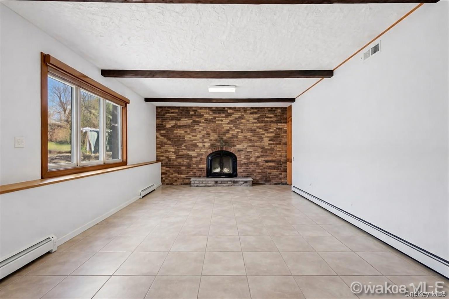 63 Farview Road Carmel, NY 10512 - Photo 18 of 38 An expansive sunken family room anchored by a brick wood burning fireplace, blending warmth with a bold architectural statement