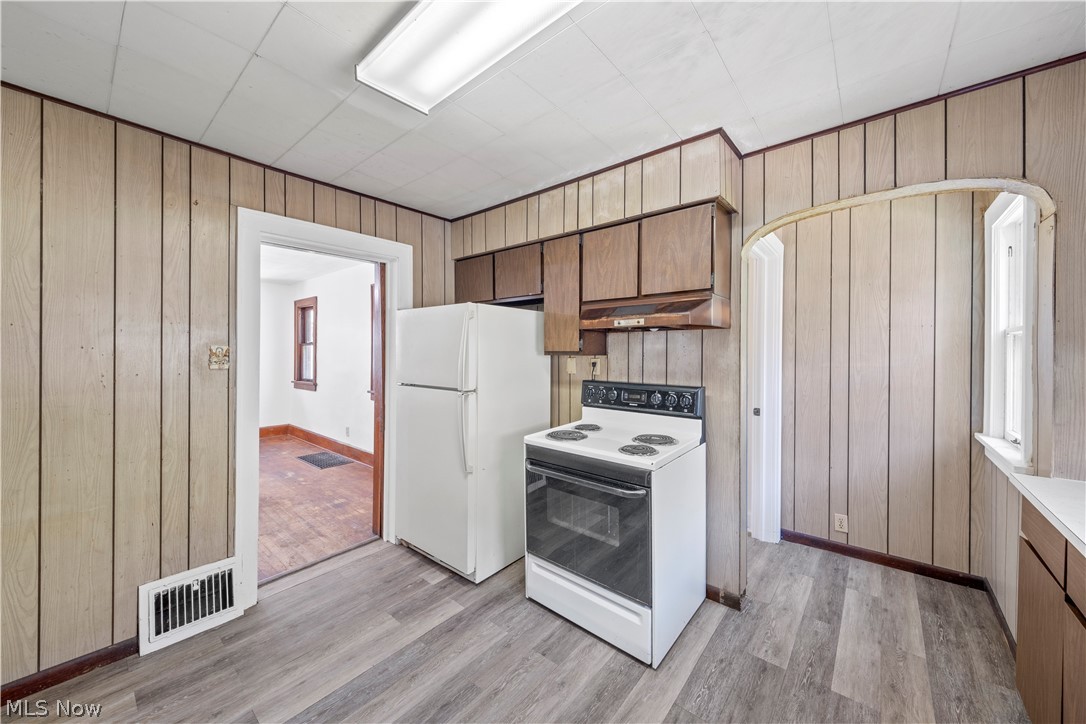 317 Ruckel Road Akron, OH 44305 - Photo 21 of 30 Kitchen featuring white appliances, wooden walls, and light hardwood / wood-style flooring