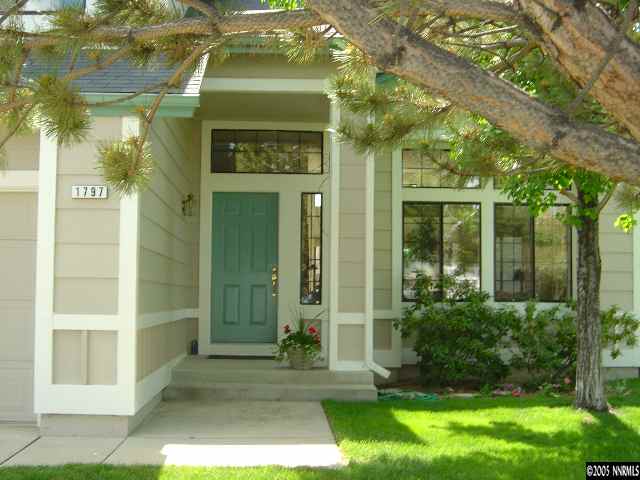 1797 Fox Run Road Reno, NV 89523 - Photo 2 of 9 a view of a brick house with a large windows and a yard with plants and large trees