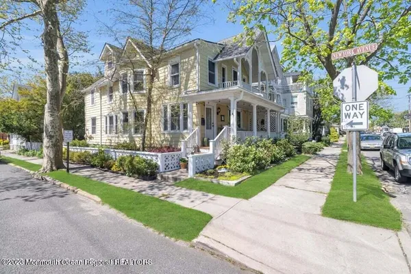 a front view of a house with a yard and potted plants