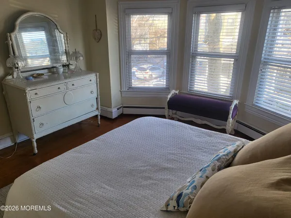 a bedroom with a bed and a dresser next to a window