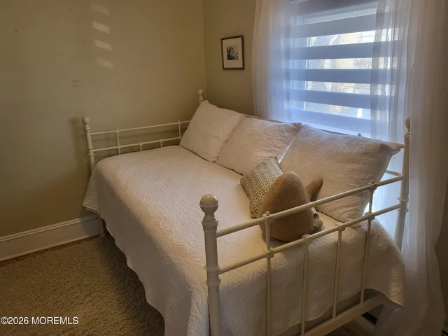 a bed sitting in a bedroom next to a window