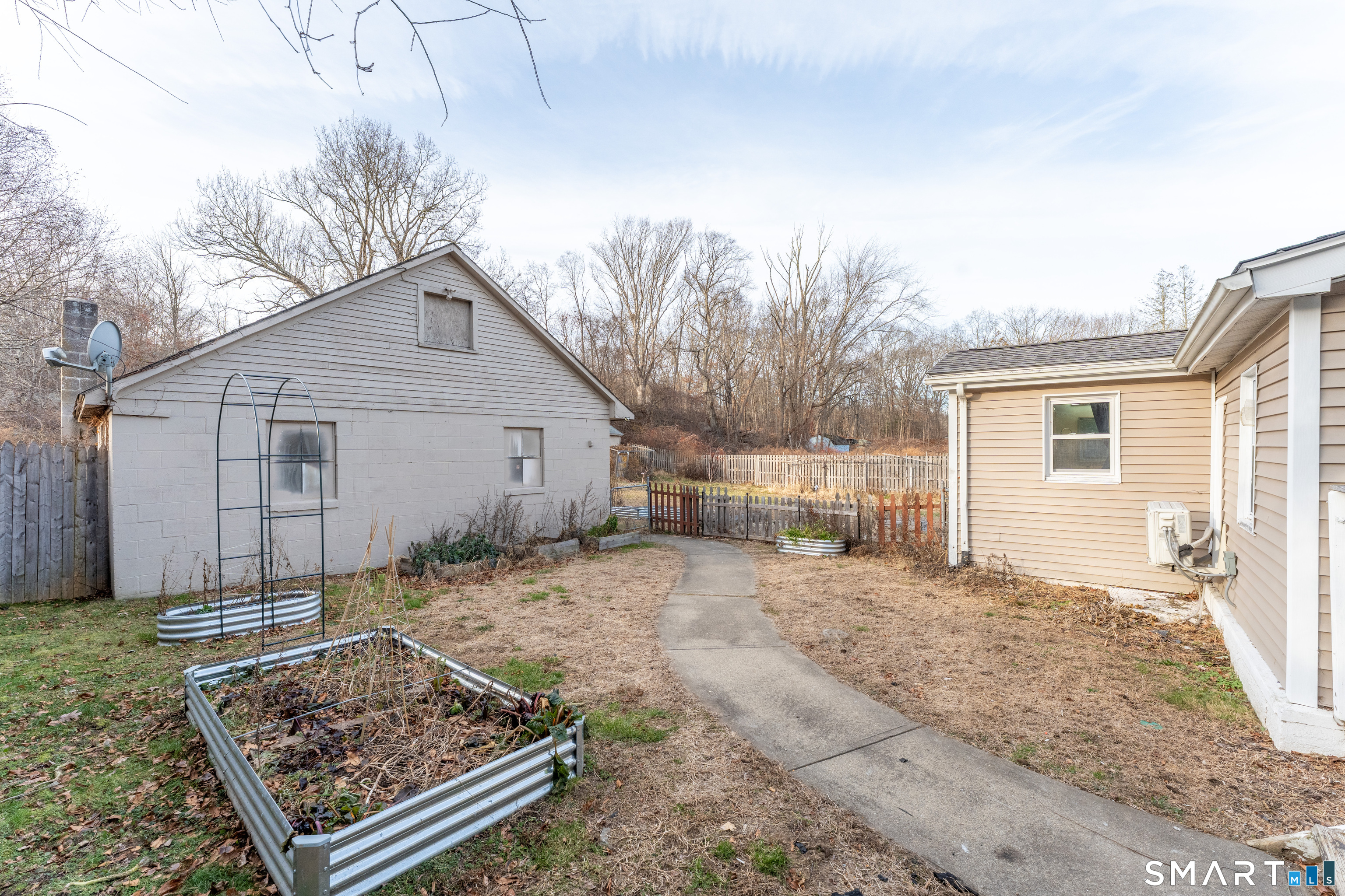 92 Hunters Avenue Norwich, CT 06380 - Photo 12 of 36 a view of a house with a small yard and wooden fence