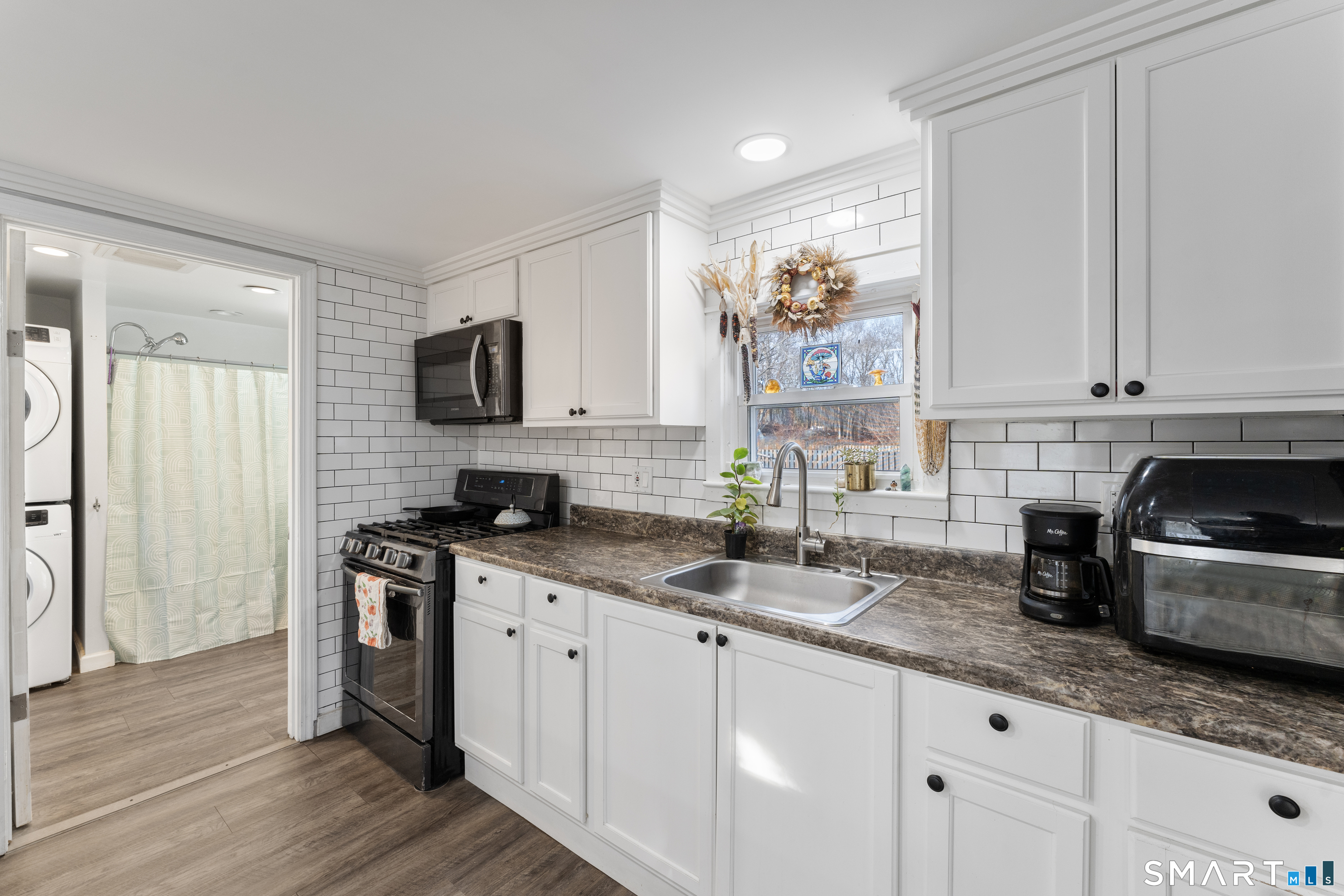 92 Hunters Avenue Norwich, CT 06380 - Photo 22 of 36 a kitchen with granite countertop a sink stainless steel appliances and white cabinets