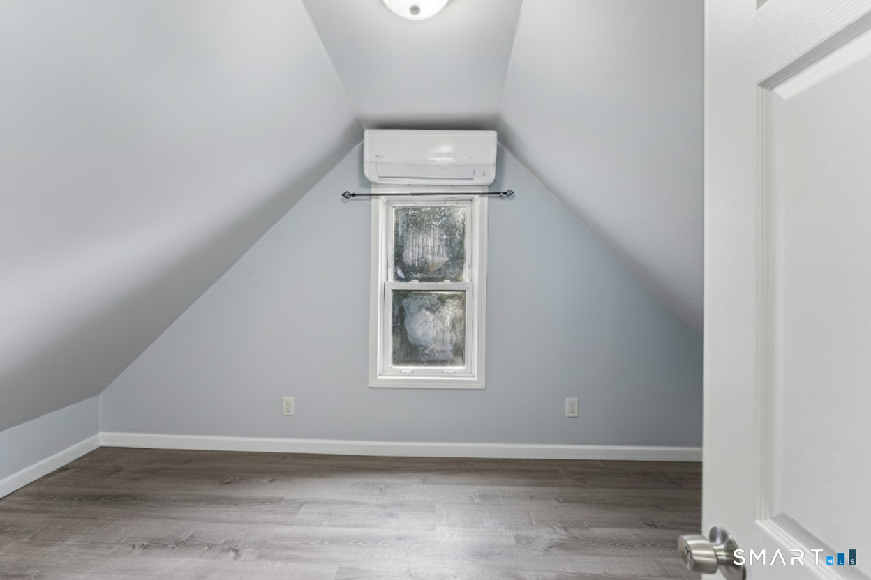 92 Hunters Avenue Norwich, CT 06380 - Photo 32 of 36 an empty room with wooden floor fan and windows