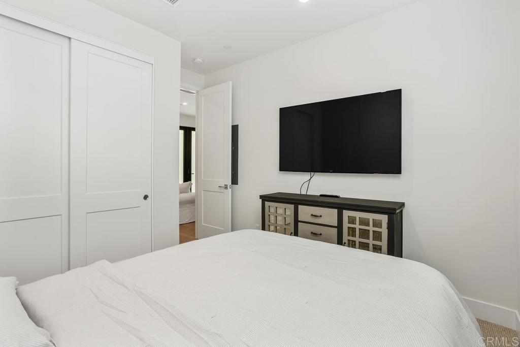 1756 Whaley Street Oceanside, CA 92054 - Photo 16 of 26 a bedroom with a bed and a flat screen tv