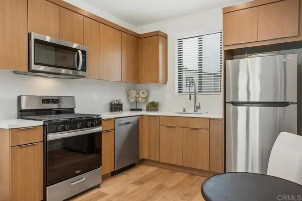 a kitchen with stainless steel appliances granite countertop a stove a sink dishwasher and a microwave oven with cabinets