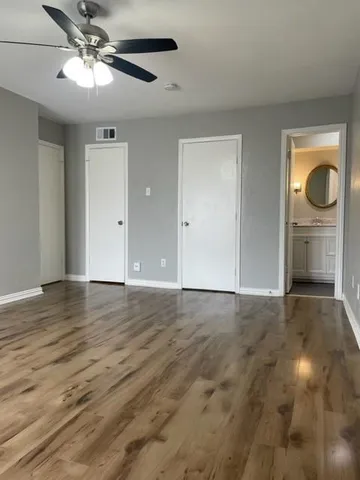 a view of an empty room and window and wooden floor