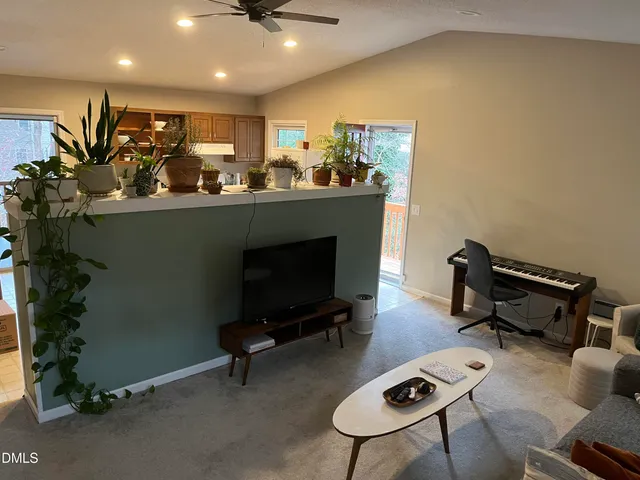 a living room with furniture a pool table and a potted plant