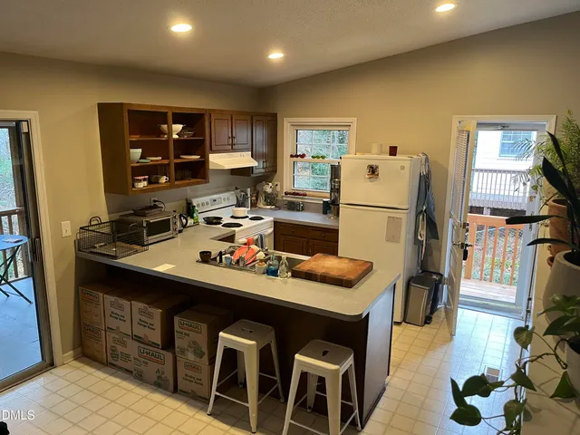 a kitchen with a refrigerator a stove a sink dishwasher and a refrigerator with wooden floor