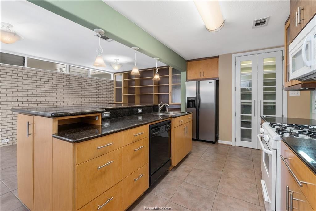 401 Helena Street Bryan, TX 77801 - Photo 9 of 21 a kitchen with stainless steel appliances granite countertop a sink stove and refrigerator