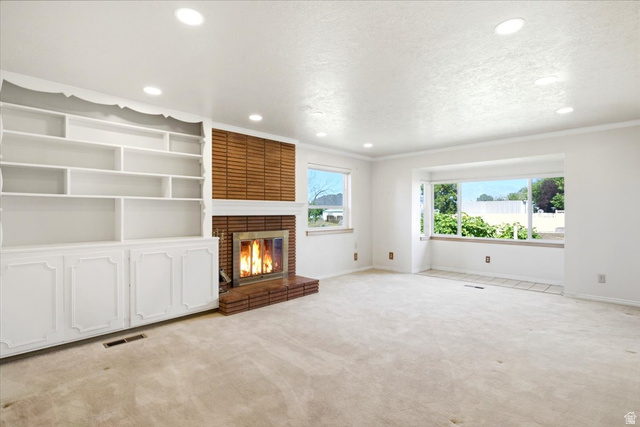 2252 West 800 North Clinton, UT 84015 - Photo 6 of 38 Living area featuring a brick fireplace with a wood mantle, built-in shelving and cabinetry, recessed ceiling lighting, and a bay window