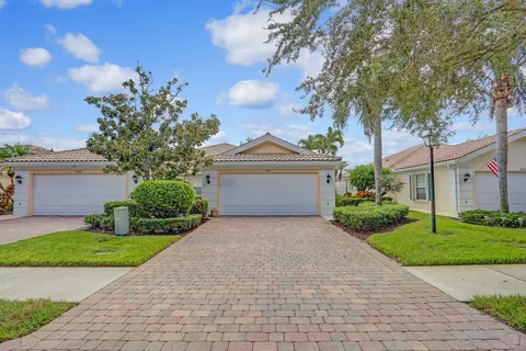 a front view of a house with a yard and a garden