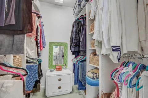 a bedroom with a bed a dresser and painting on the wall