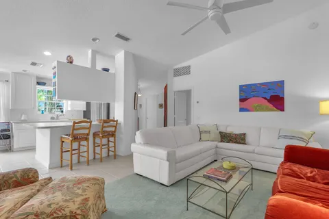 a living room with furniture kitchen view and a wooden floor