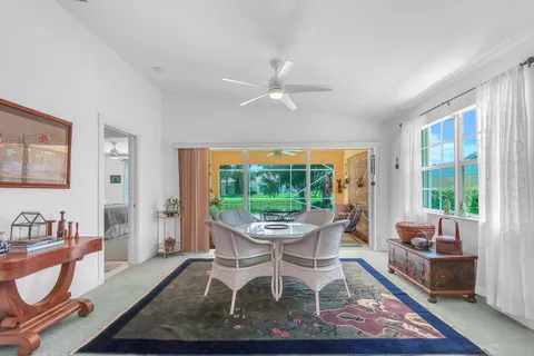 a dining room with furniture a rug and a floor to ceiling window