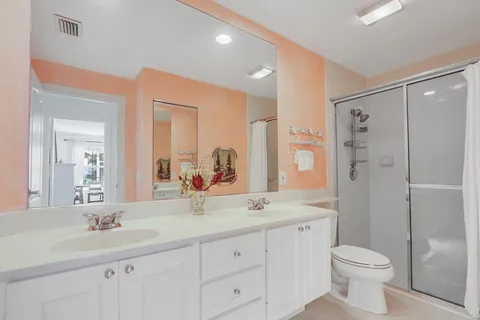 a bathroom with a double vanity sink toilet and shower