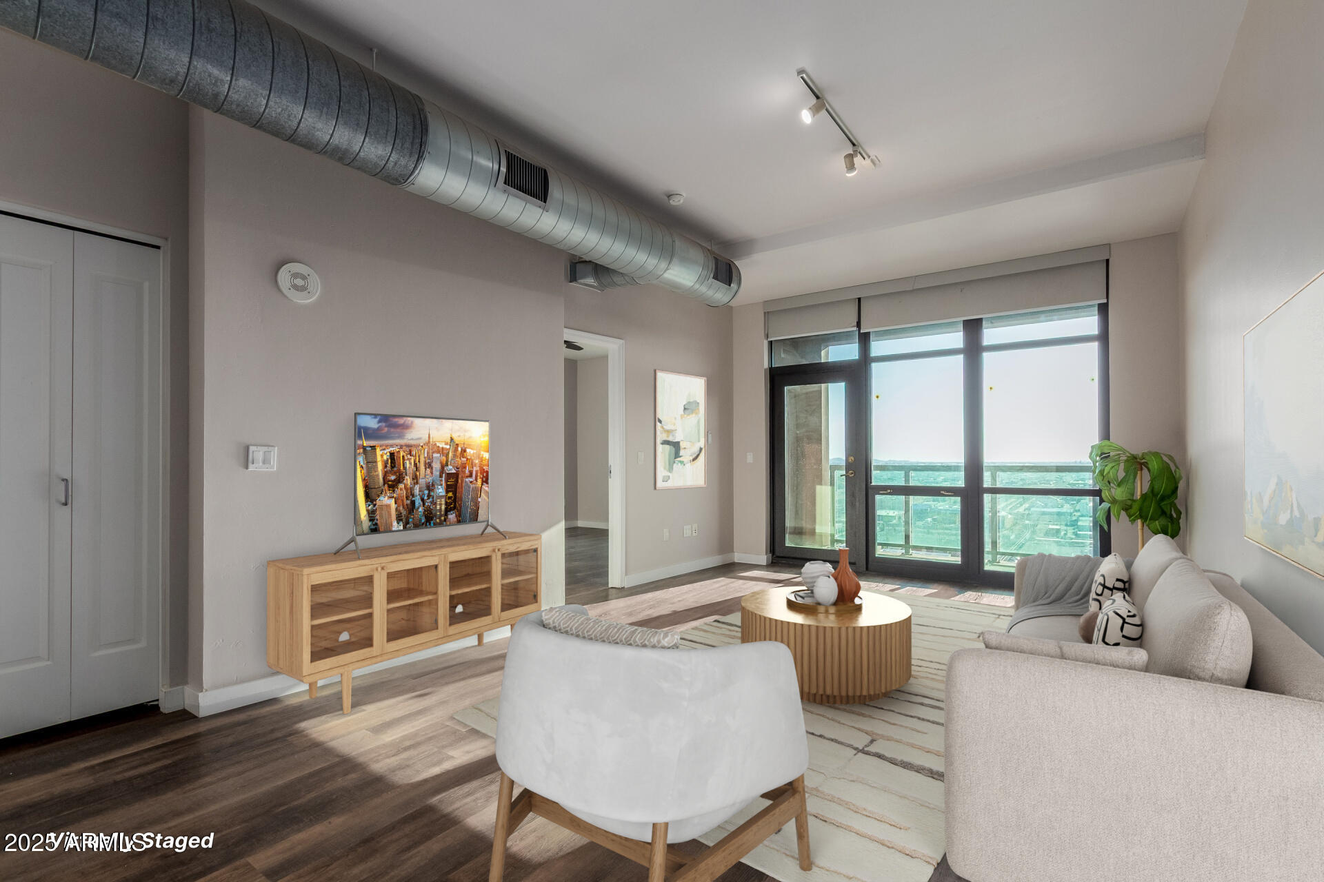 a living room with furniture large window and wooden floor