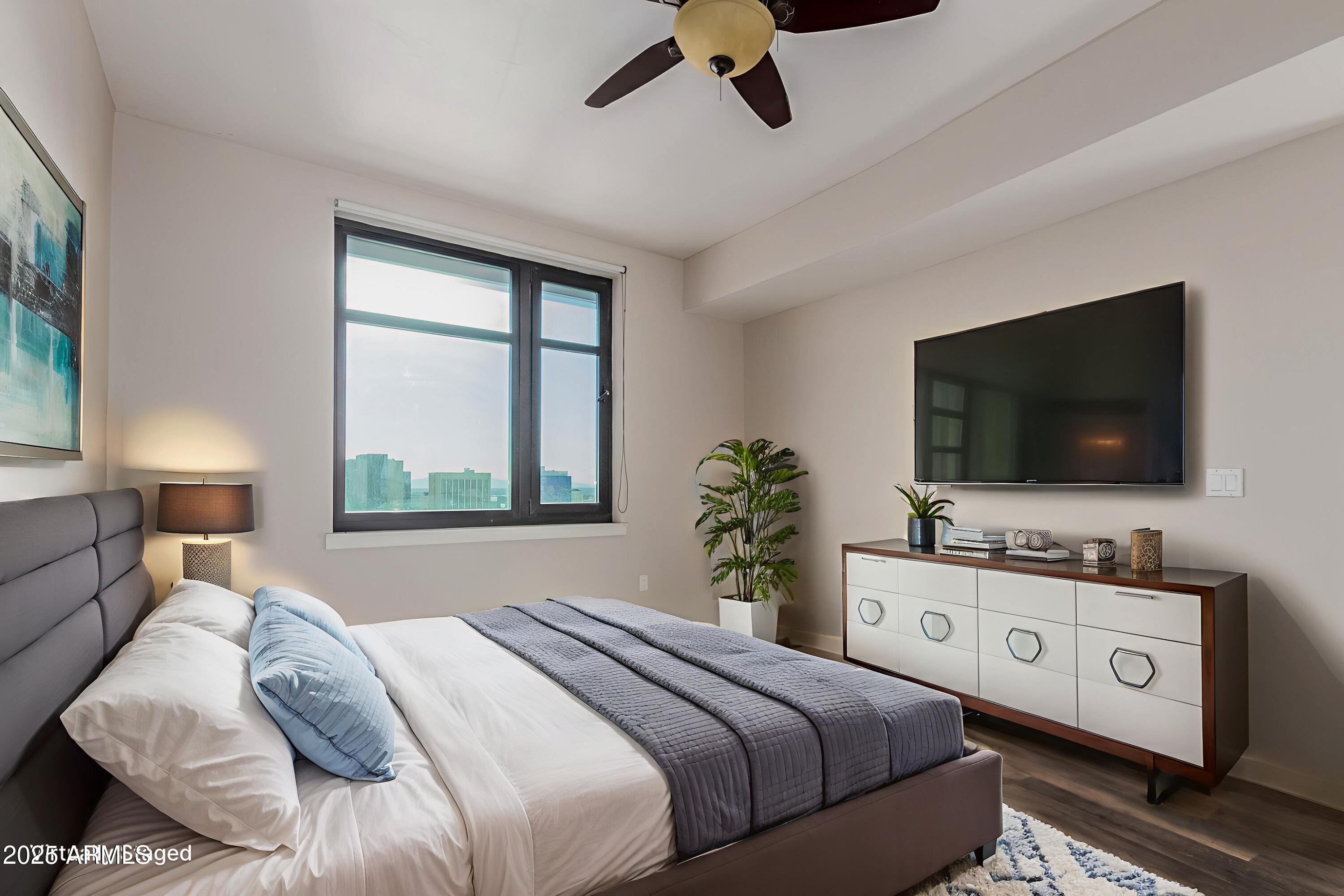 310 South 4th Street, Unit 1902 Phoenix, AZ 85004 - Photo 14 of 37 a bedroom with a bed and a flat screen tv