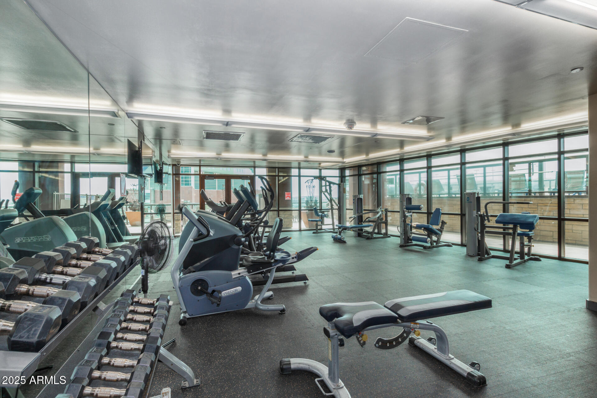 310 South 4th Street, Unit 1902 Phoenix, AZ 85004 - Photo 26 of 37 a room with gym equipment and large glass windows