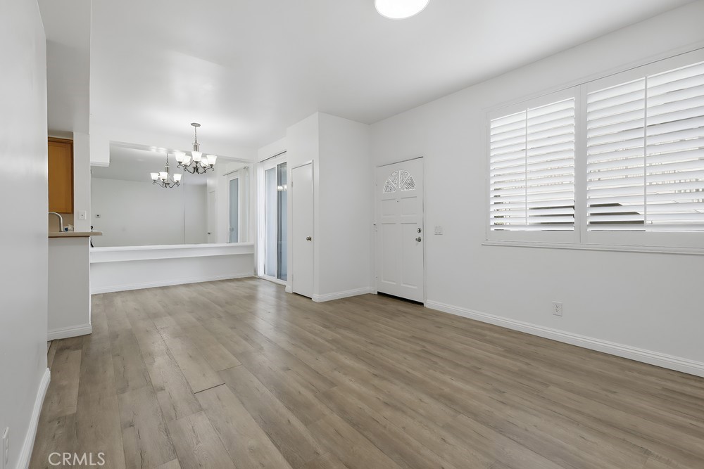 115 Remington Irvine, CA 92620 - Photo 4 of 25 an empty room with wooden floor and chandelier