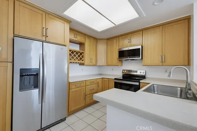 a kitchen with stainless steel appliances a refrigerator sink and microwave