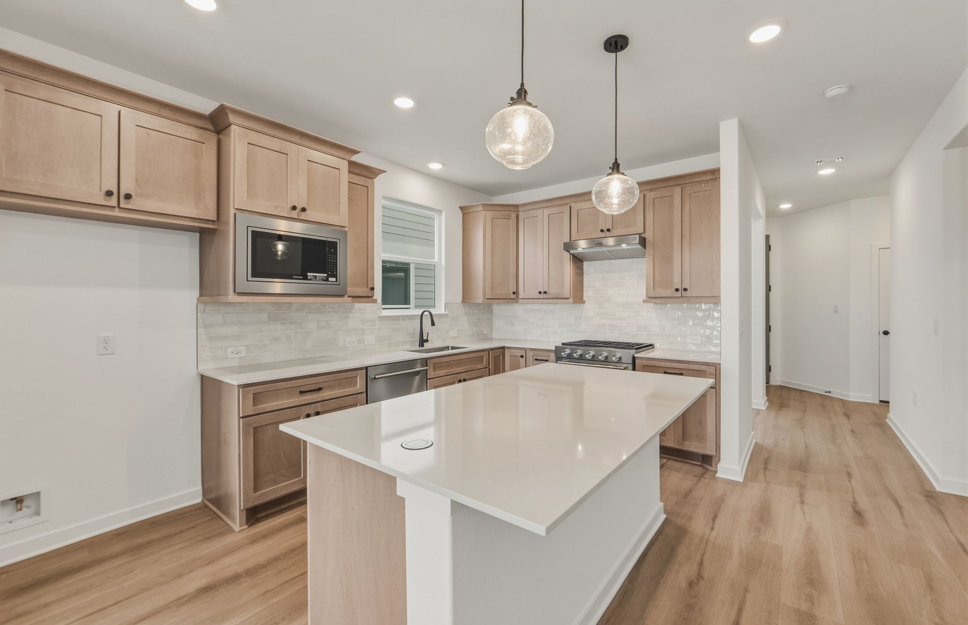 207 Smokestack Lane Georgetown, TX 78633 - Photo 3 of 21 a large kitchen with stainless steel appliances kitchen island granite countertop a sink a stove and a wooden floors