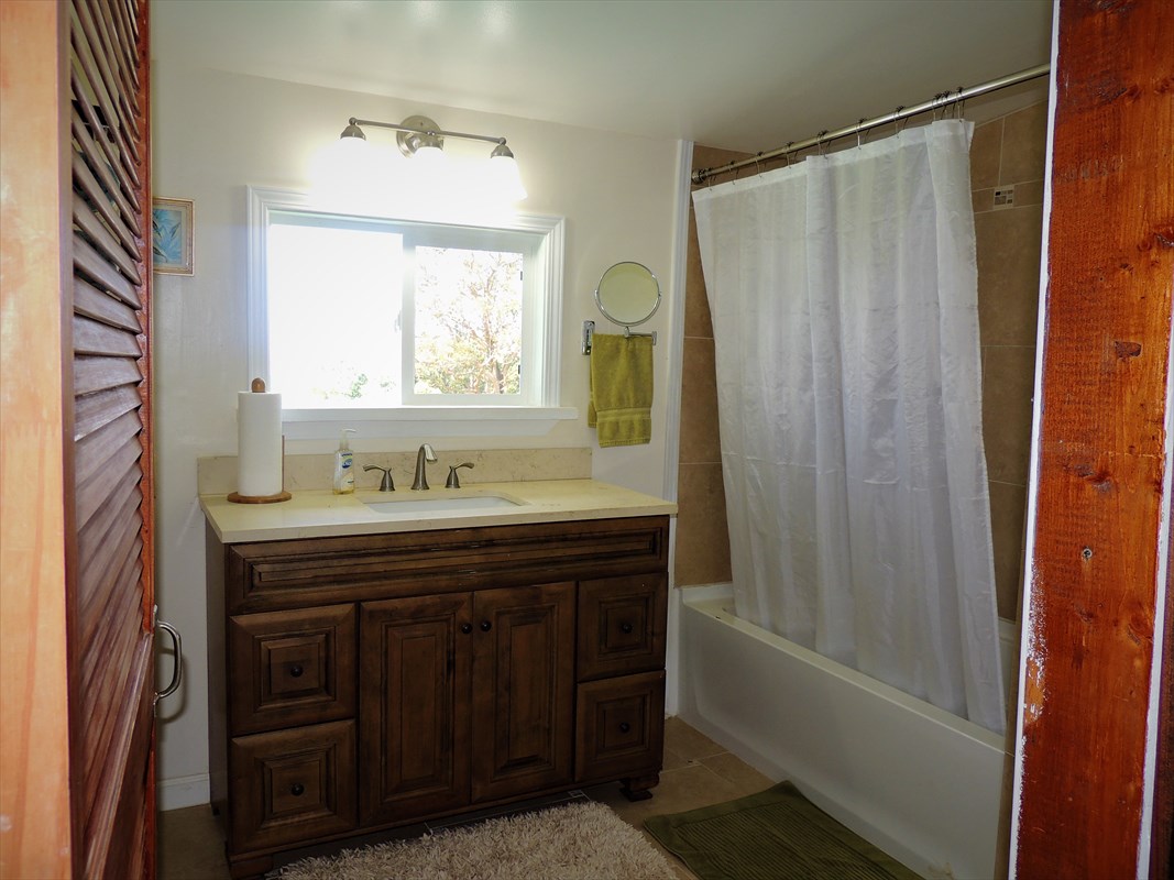 81-1073 Captain Cook Road, Unit A Captain Cook, HI 96704 - Photo 14 of 25 a bathroom with a sink a mirror and a bathtub