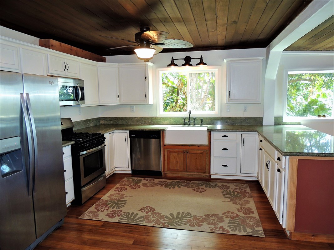 81-1073 Captain Cook Road, Unit A Captain Cook, HI 96704 - Photo 2 of 25 a kitchen with granite countertop a sink stainless steel appliances and cabinets