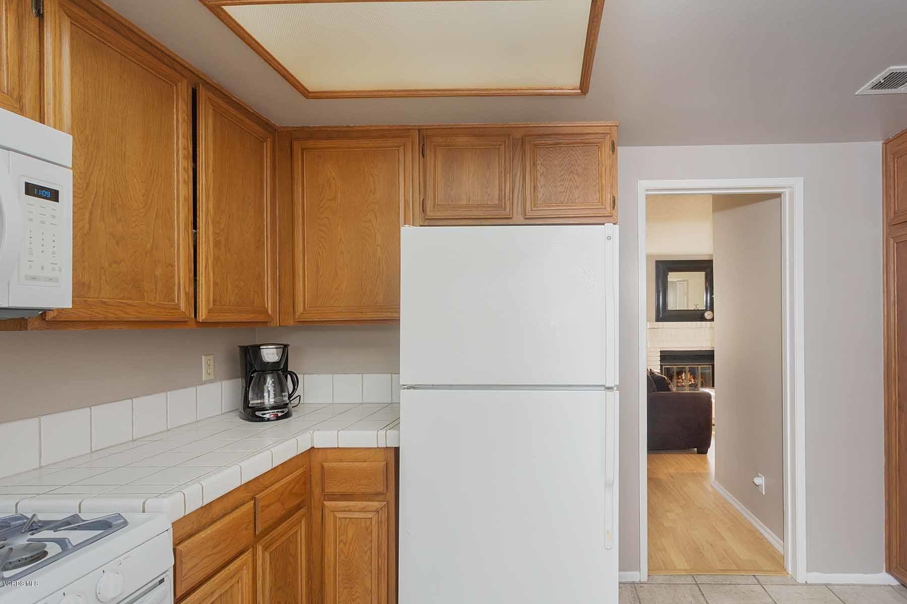 3902 Cochran Street, Unit 4 Simi Valley, CA 93063 - Photo 14 of 26 a kitchen with a refrigerator and cabinets